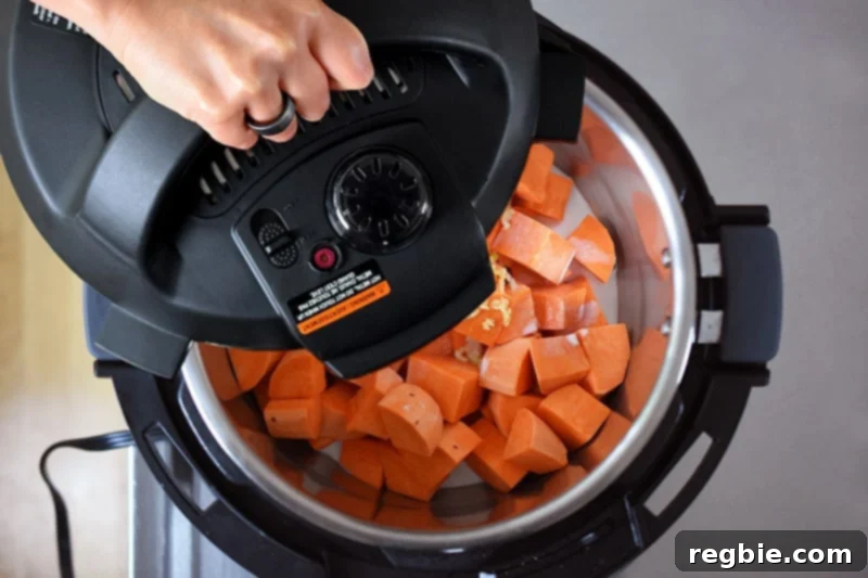 Putting the lid on an Instant Pot to cook mashed sweet potatoes.