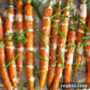 An overhead shot of air fryer roasted carrots topped with ginger sesame dressing and fresh chives, a quick and easy side.