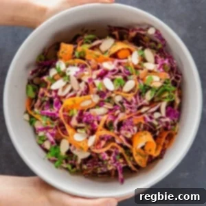 Overhead shot of Whole30 and paleo red cabbage slaw with tangy carrot and ginger dressing, vibrant and crunchy.