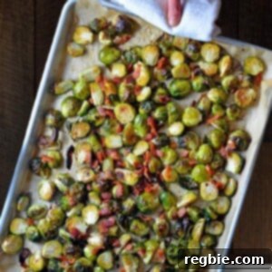 An overhead shot of a rimmed baking sheet filled with Roasted Brussels sprouts with Bacon, perfectly caramelized and crispy.