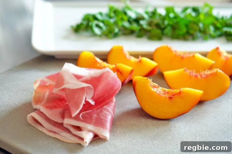 Quartered peaches, a slice of prosciutto, and washed watercress sitting on a cutting board.