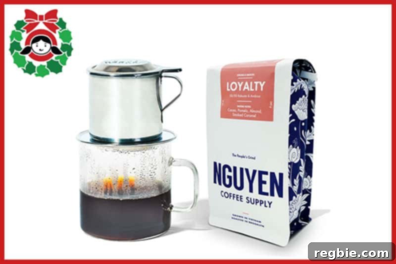 A Vietnamese Coffee Filter over a clear glass mug with a bag of Nguyen Coffee Supply coffee, a delightful coffee gift.