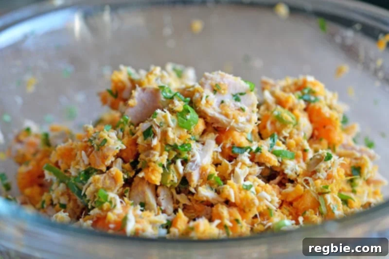 The ingredients for spicy tuna cakes mixed together in a bowl.