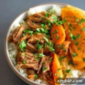 An overhead shot of a white bowl filled with Instant Pot Cheater Pork and Cabbage Stew over some cauliflower rice.