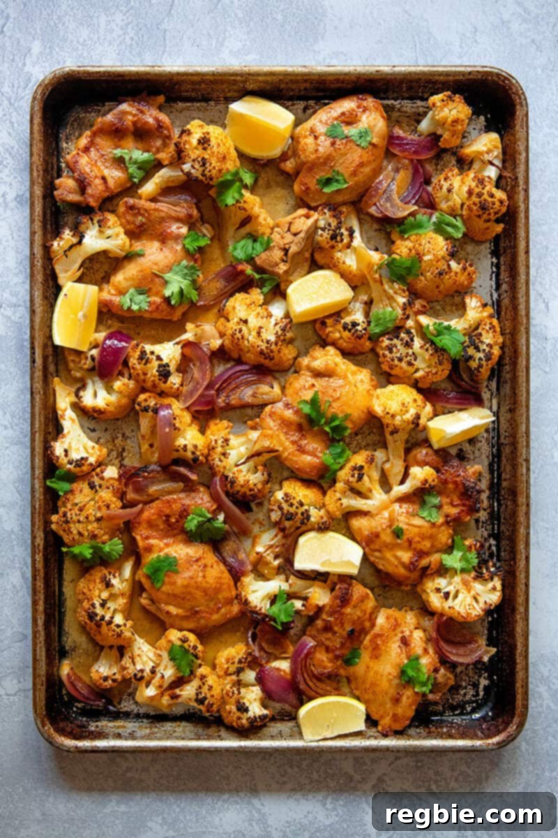 An overhead shot of healthy and easy sheet pan Chicken Tandoori, a Whole30 and keto-friendly dinner featuring perfectly roasted chicken and vegetables.