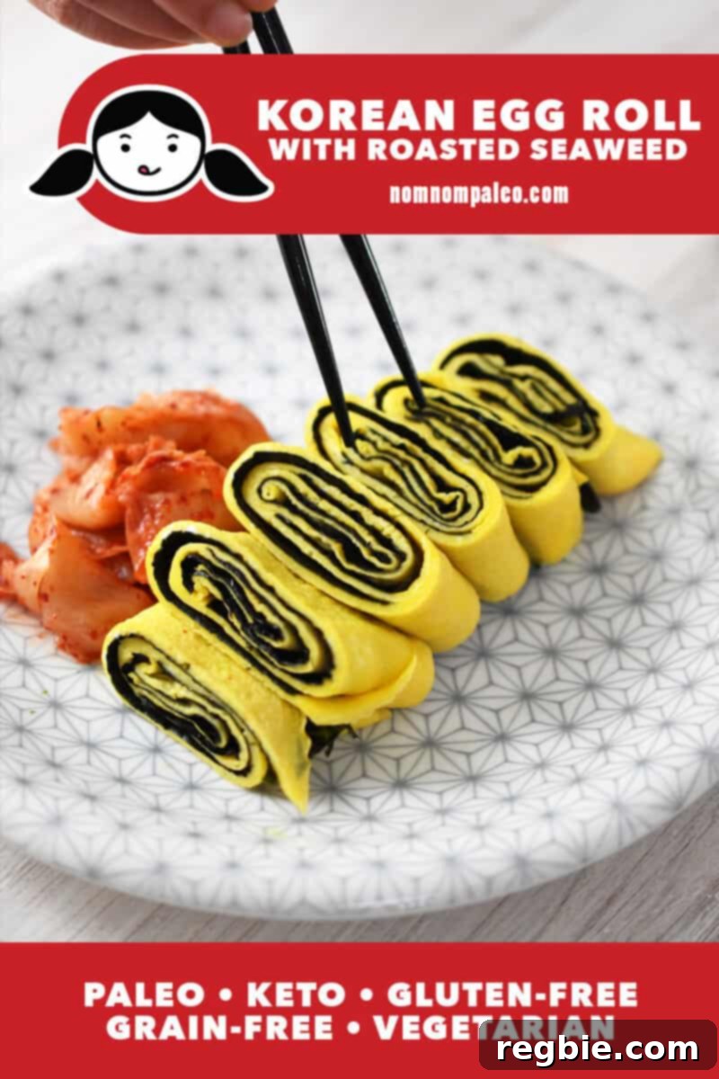 A white plate with a gray flower pattern is topped with a Korean rolled egg omelet with seaweed. There is a small pile of kimchi on the side and a pair of chopsticks is lifting up a piece. The red banner at the bottom says paleo, keto, vegetarian, and gluten-free.