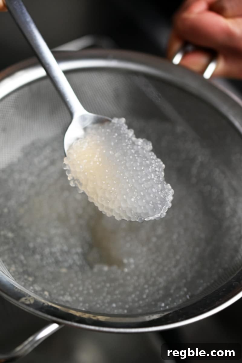 Tropical Mango Coconut Tapioca 5 A spoonful of cooked small tapioca pearls. They are translucent and look like small rubber balls.