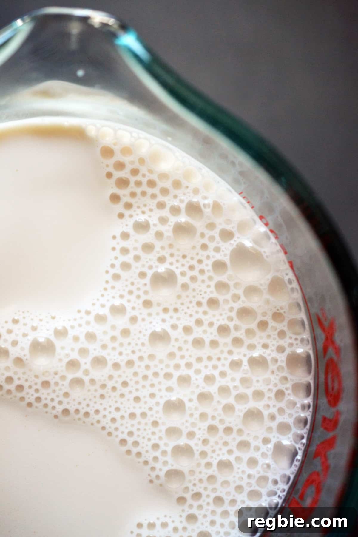 An overhead shot of a measuring cup filled with homemade almond milk.