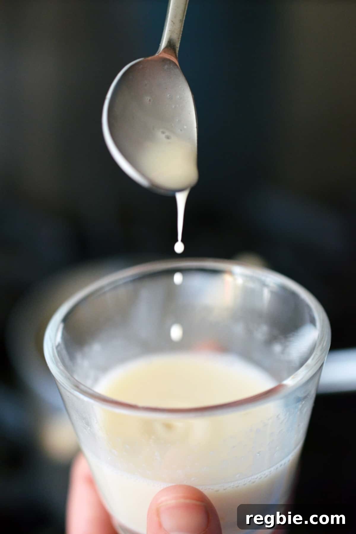 Transferring warmed almond milk into a glass jar with gelatin.