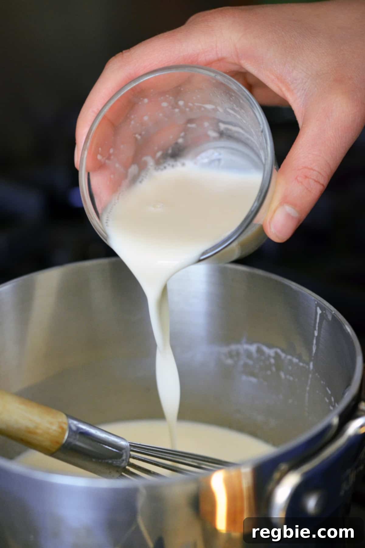 Pouring some diluted gelatin into a saucepan to make Panna Cotta.