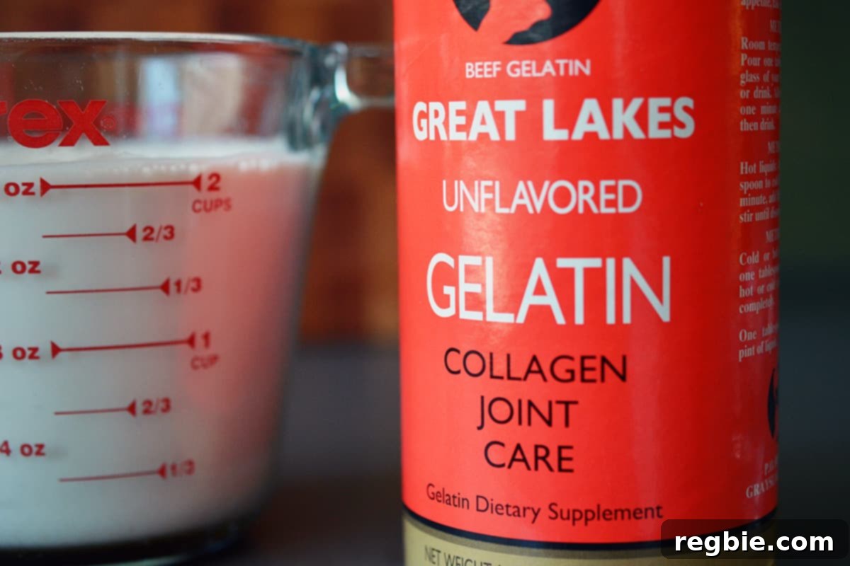 A measuring cup filled with a white liquid is next to a jar of gelatin.