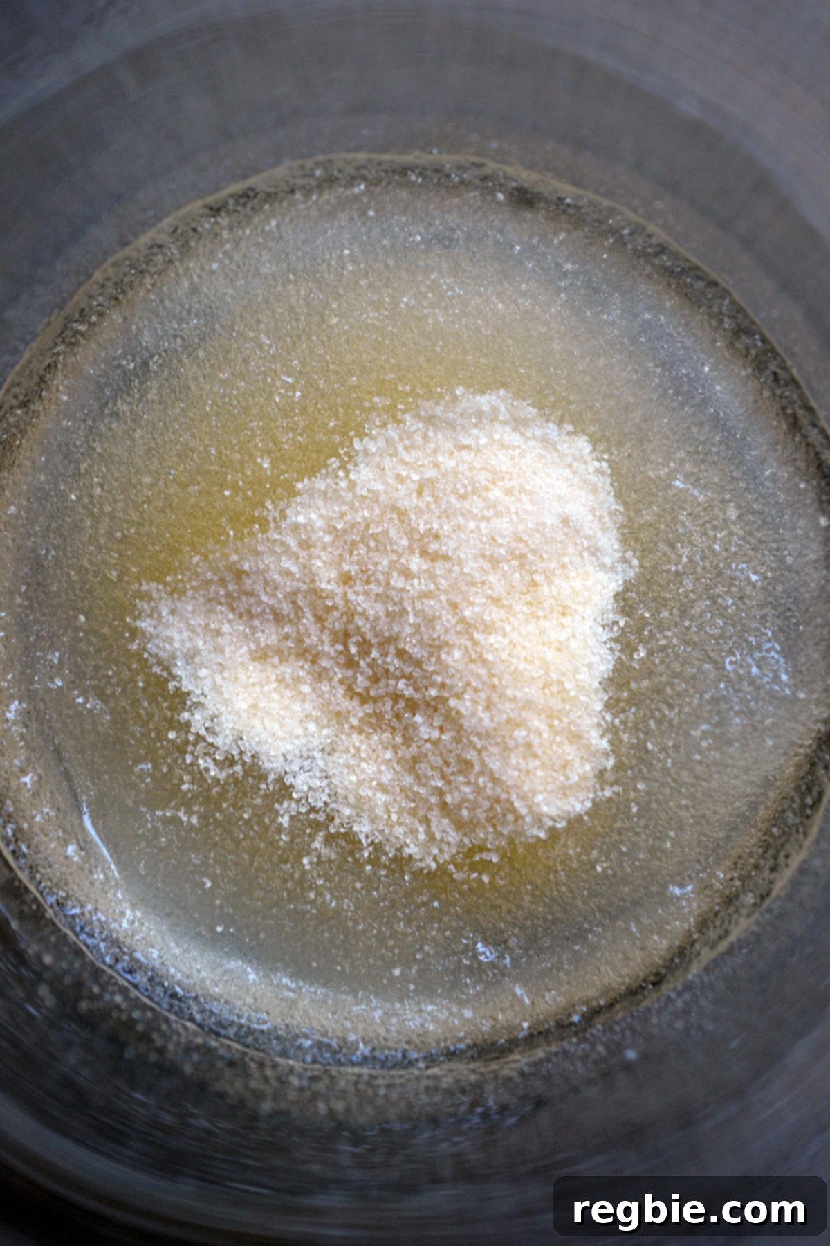 Powdered gelatin blooming in a small glass.