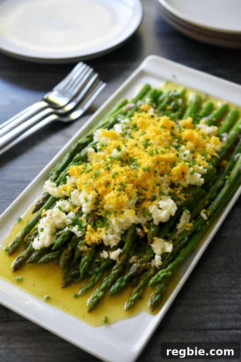 Whole30 Keto Paleo Asparagus Mimosa 3 Side shot of Asparagus mimosa on a rectangular white platter with forks and plates on the side.