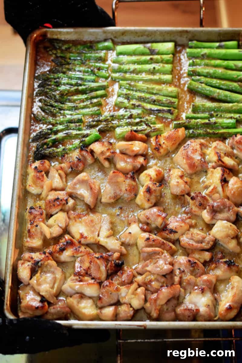 Simple Sheet Pan Chicken & Asparagus: Paleo Perfection 15 An overhead shot captures the sheet pan chicken and asparagus, perfectly cooked and ready to be removed from the oven. The chicken is golden brown, asparagus is tender-crisp, and the sauce is deliciously thickened.