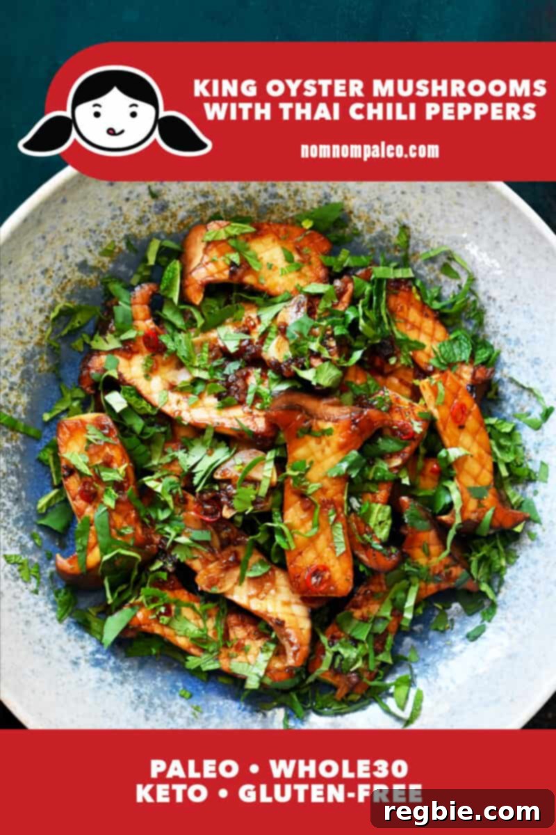 An overhead shot of king oyster mushrooms with Thai Chili peppers, lime juice, and fresh herbs in a light blue bowl.