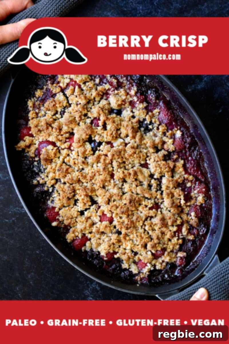 An overhead shot of a berry crisp in an oval baking dish. There is a red banner at the bottom that reads paleo, grain-free, gluten-free, and vegan.