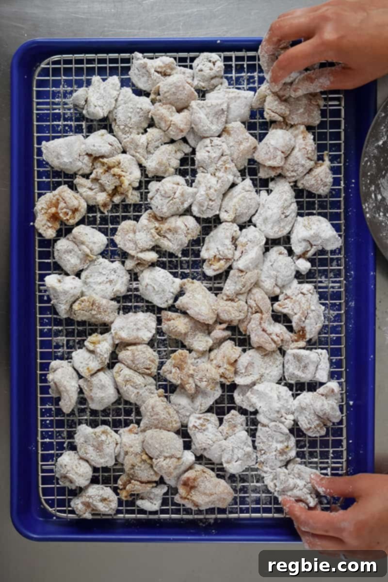 An overhead shot of battered Taiwanese Popcorn chicken on a wire rack in a rimmed baking sheet.
