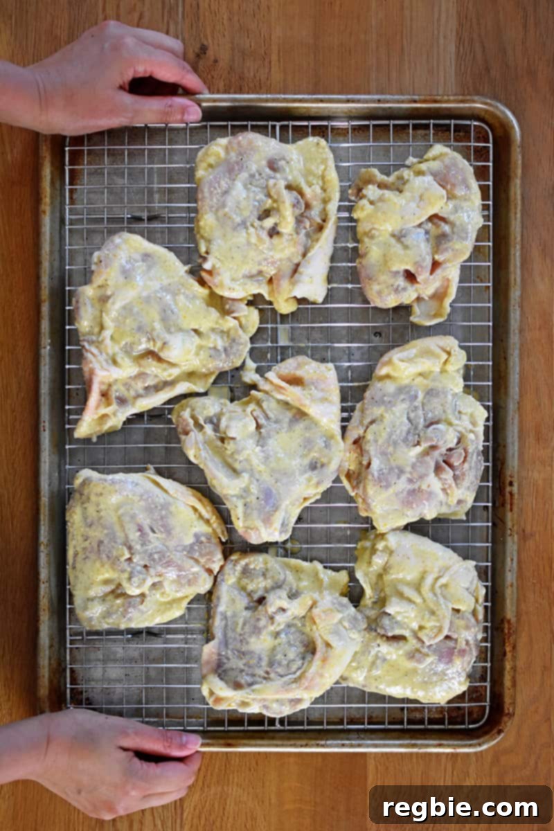 An overhead shot of someone holding a baking tray of mojo chicken ready for the oven.