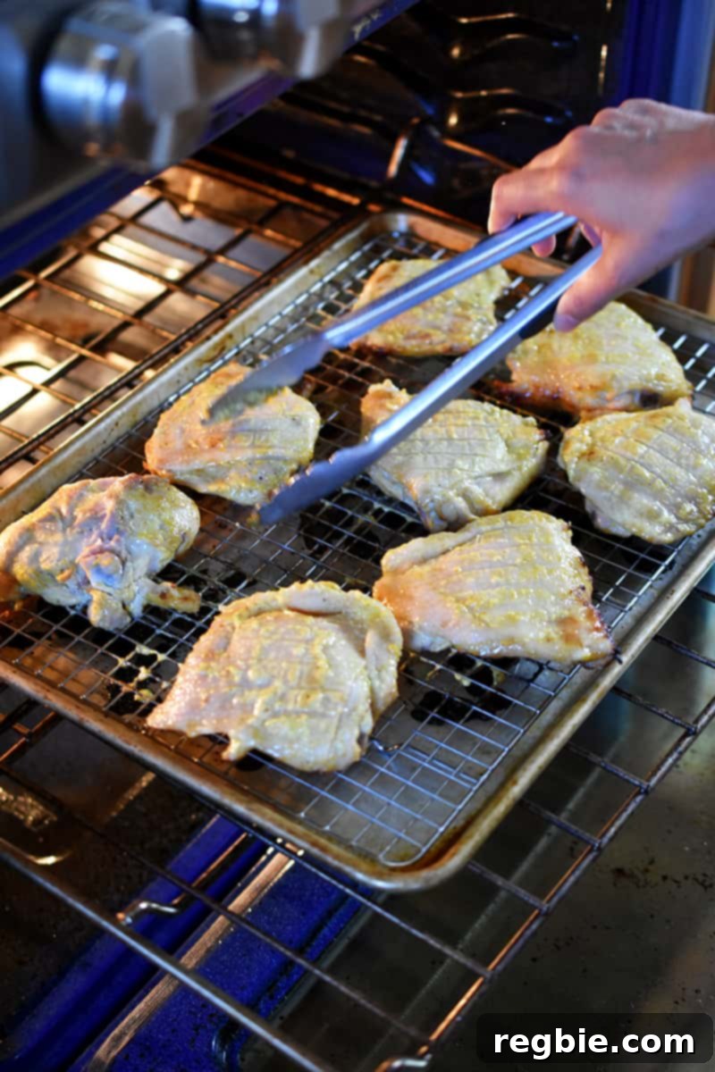 Flipping mojo chicken skin-side up at the halfway point of roasting