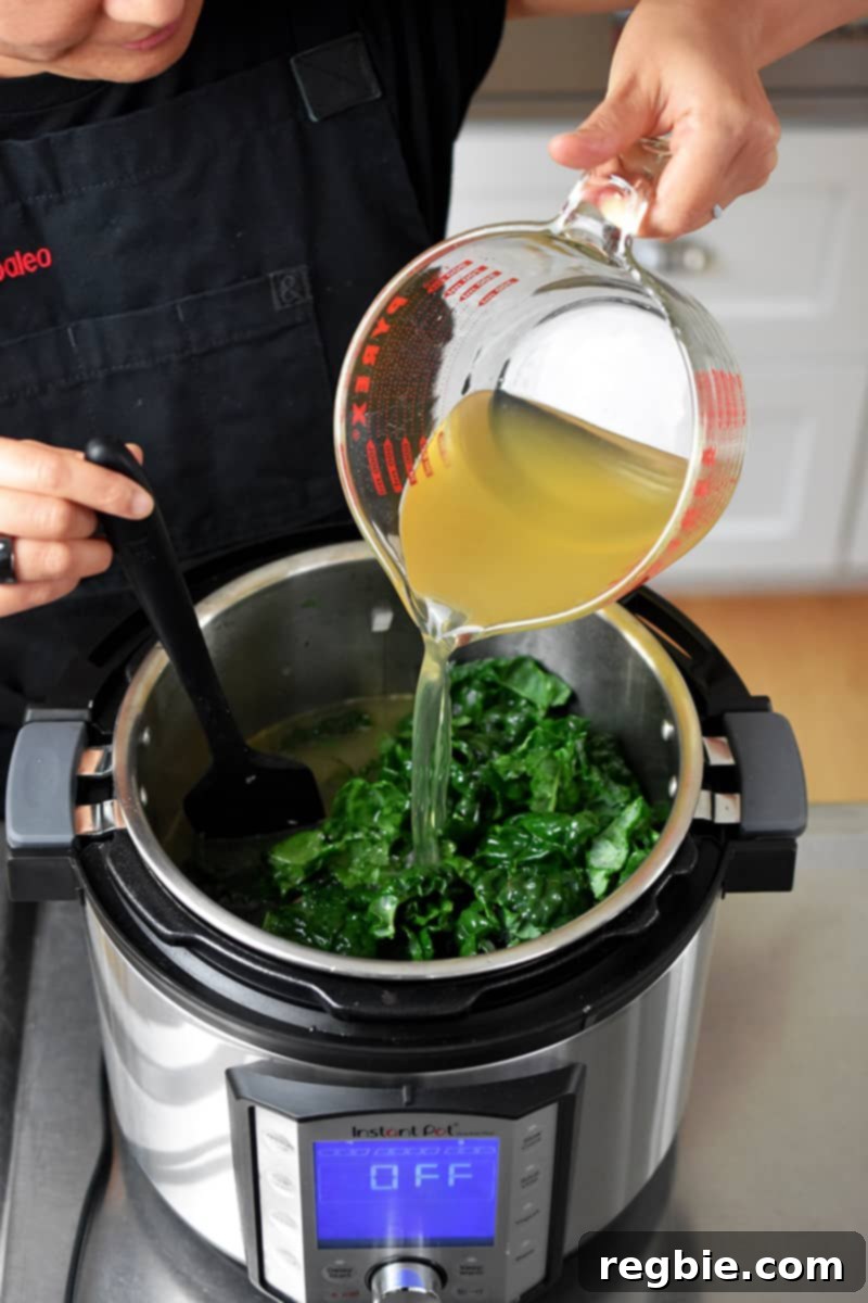 Pouring bone broth into an Instant Pot filled with sautéed sausage, onions, and vegetables.