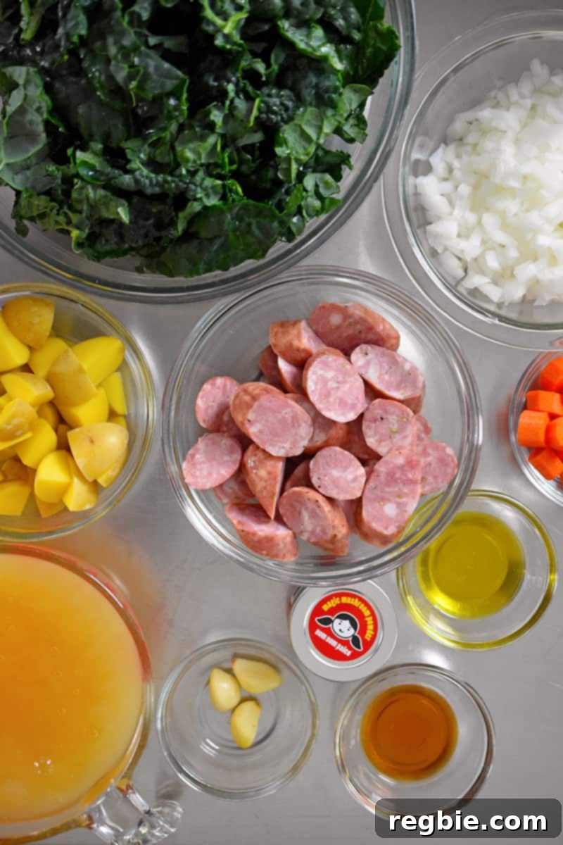 An overhead shot of all the fresh ingredients laid out for making sausage and kale soup.