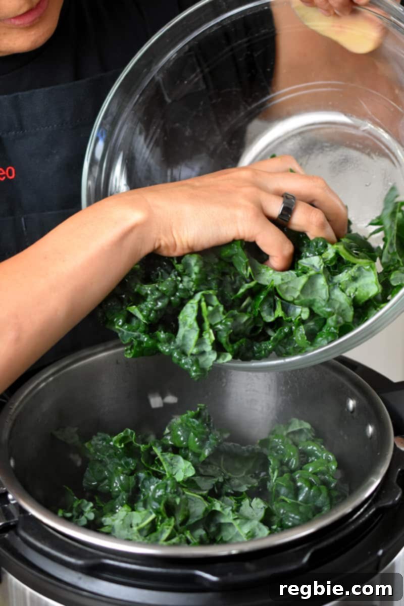 Adding chopped kale, potatoes, and carrots into an open Instant Pot.