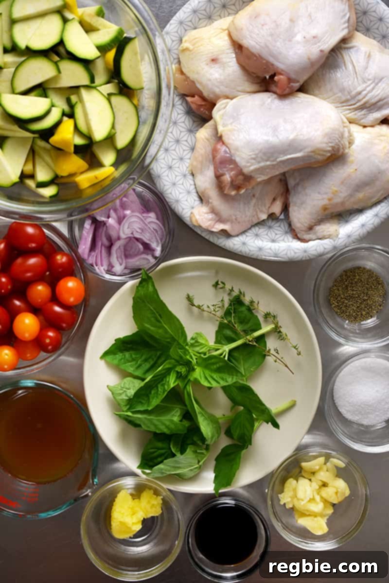 An overhead shot of the raw and prepped ingredients for crispy baked chicken thighs with summer vegetables. 