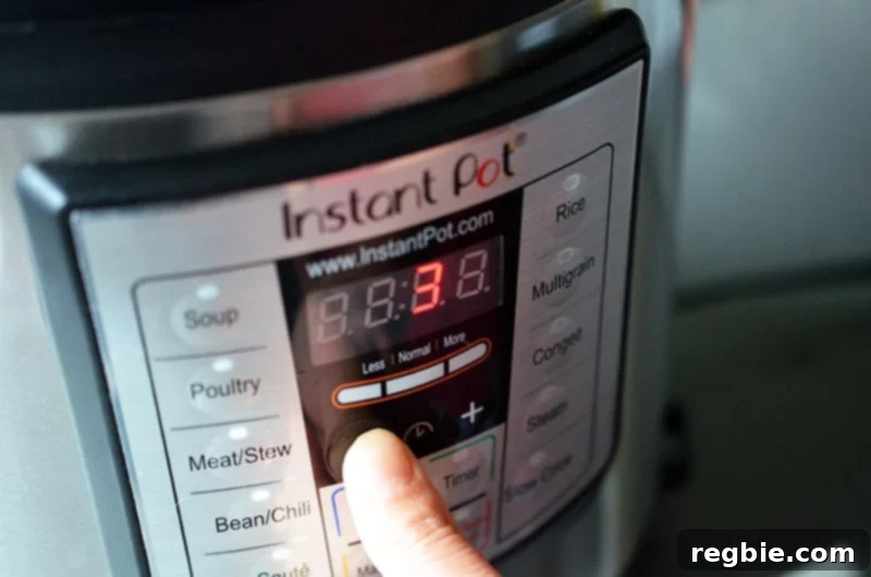 A person is programming the Instant Pot control panel to cook under high pressure, setting the timer for perfect results.