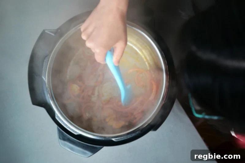 An overhead shot of onions and tomato paste cooking in the Instant Pot, forming a rich base.