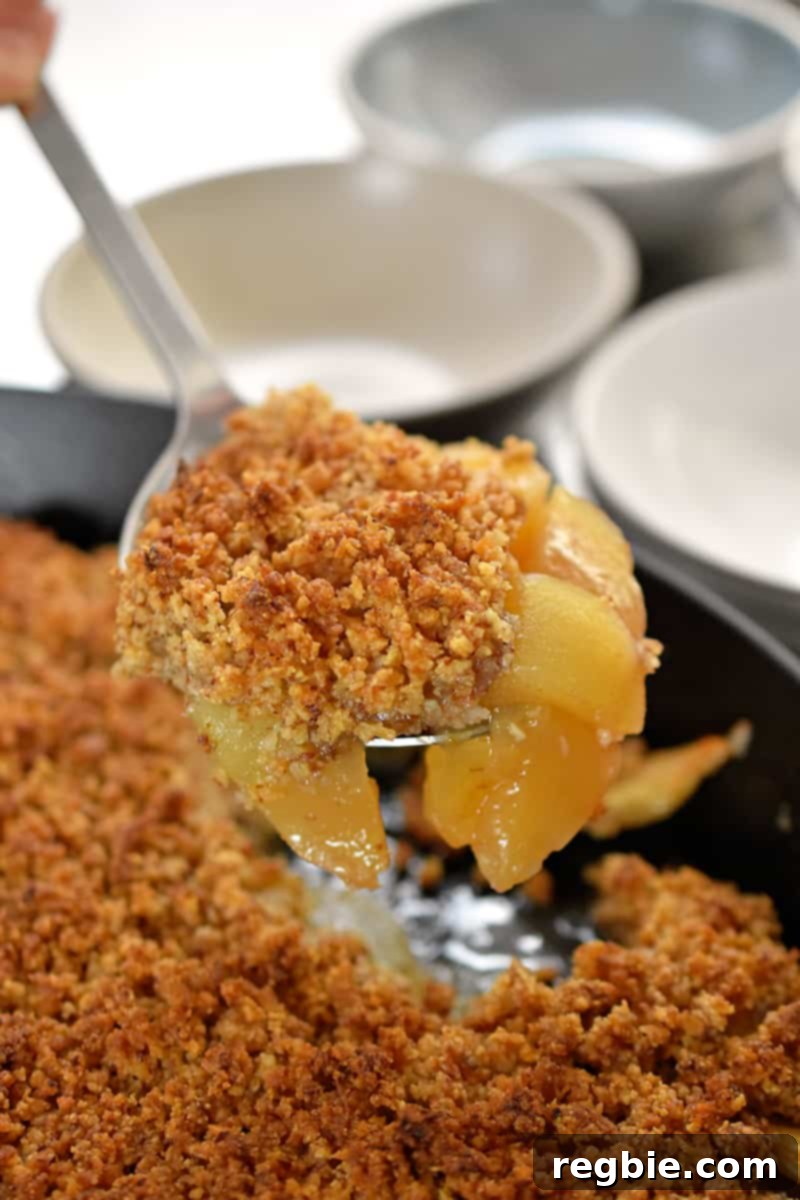 Guilt Free Apple Crisp 19 A spoon is scooping up paleo, vegan, and gluten-free apple crisp from a baking dish.