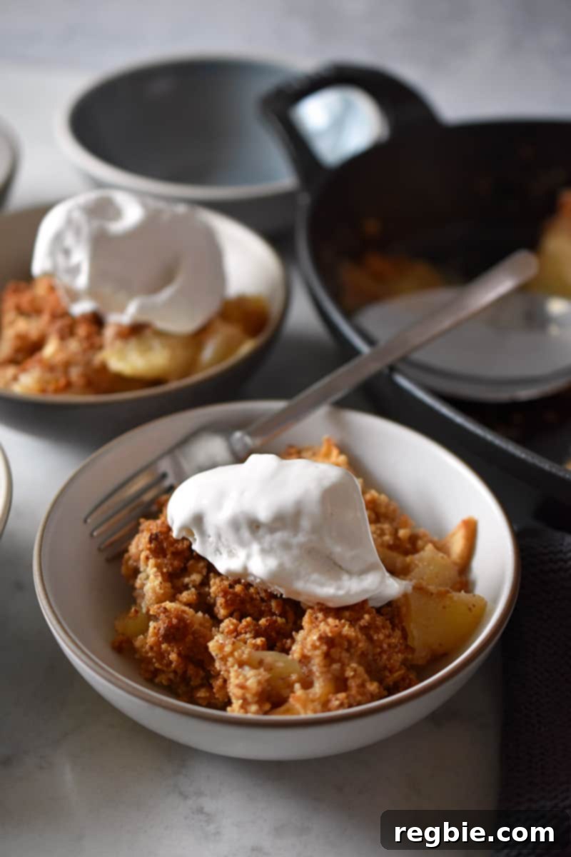 Guilt Free Apple Crisp 20 Two small dishes filled with paleo and gluten-free apple crisp and whipped coconut cream.