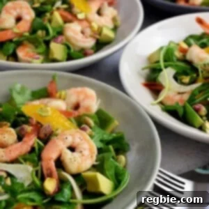 A closeup of four shallow bowls filled with shrimp and avocado salad