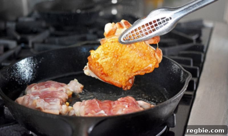 Shatteringly Crispy Chicken Thighs 8 Flipping a piece of Cracklin’ Chicken with golden, crispy skin.