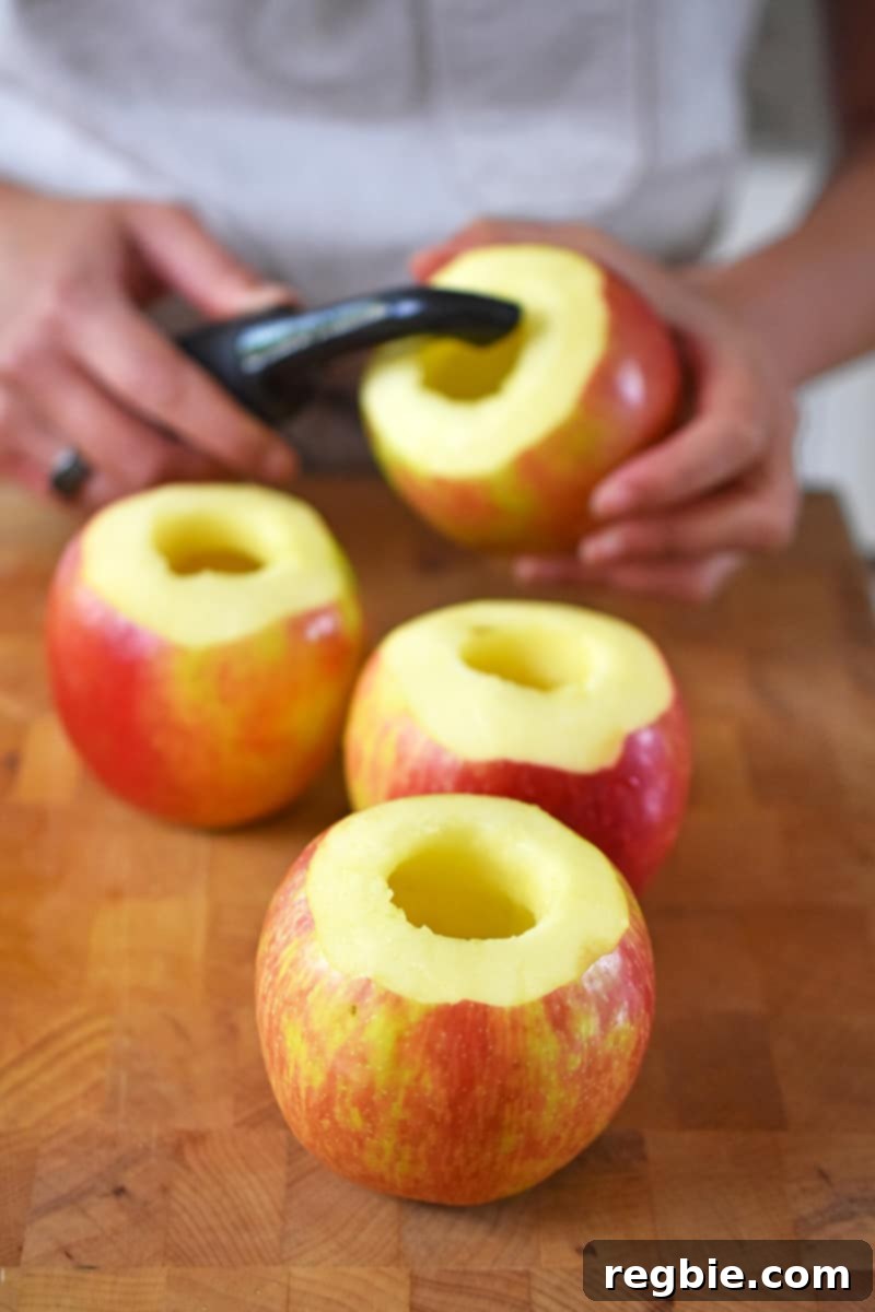 Wholesome Spiced Baked Apples 9 Four cored apples have the top peeled of their skin.