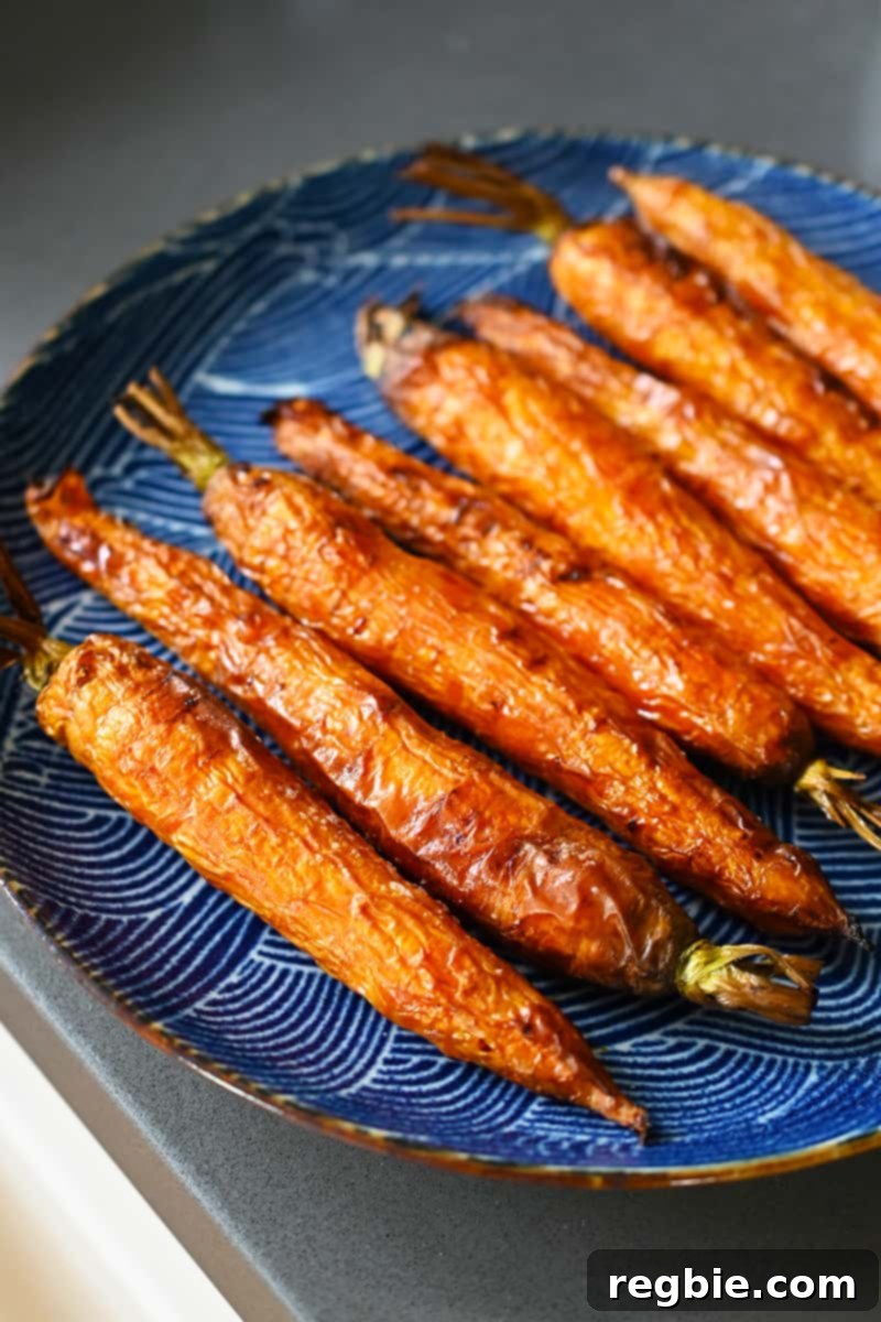 Golden Roasted Air Fryer Carrots 3 A blue plate topped with air fryer carrots that are golden brown and ready to eat.