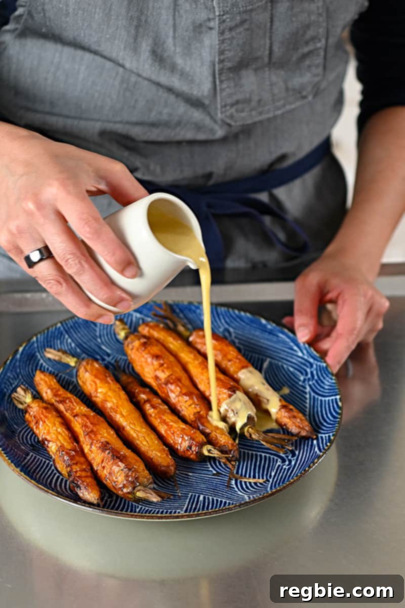 Golden Roasted Air Fryer Carrots 9 Pouring sesame ginger dressing on a plate of air fryer roasted carrots.
