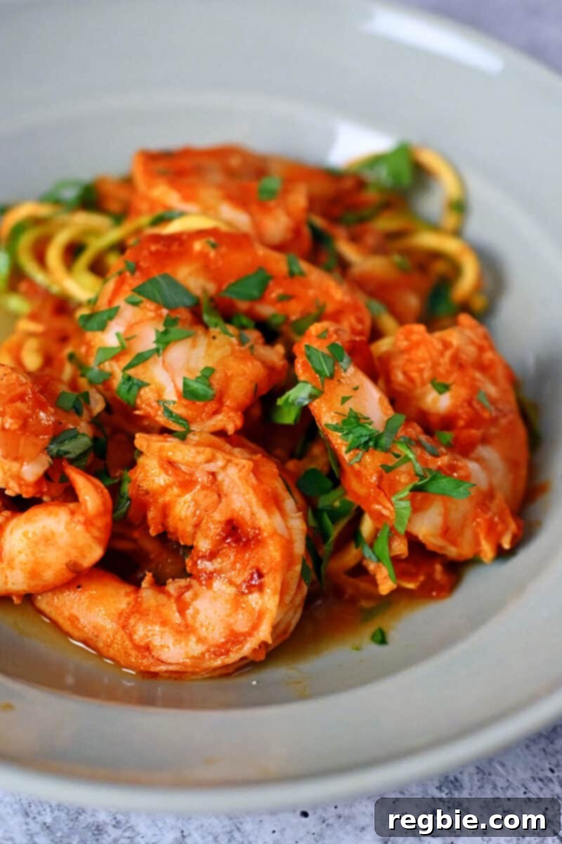 A closeup side view of Whole30, paleo, and keto spicy shrimp pasta with zucchini noodles, showing the vibrant colors and texture of the dish.