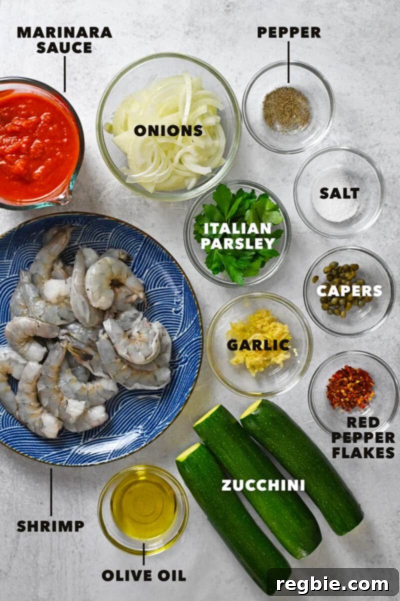 An overhead shot of all the raw ingredients neatly arranged to make paleo, Whole30, and keto spicy shrimp pasta.