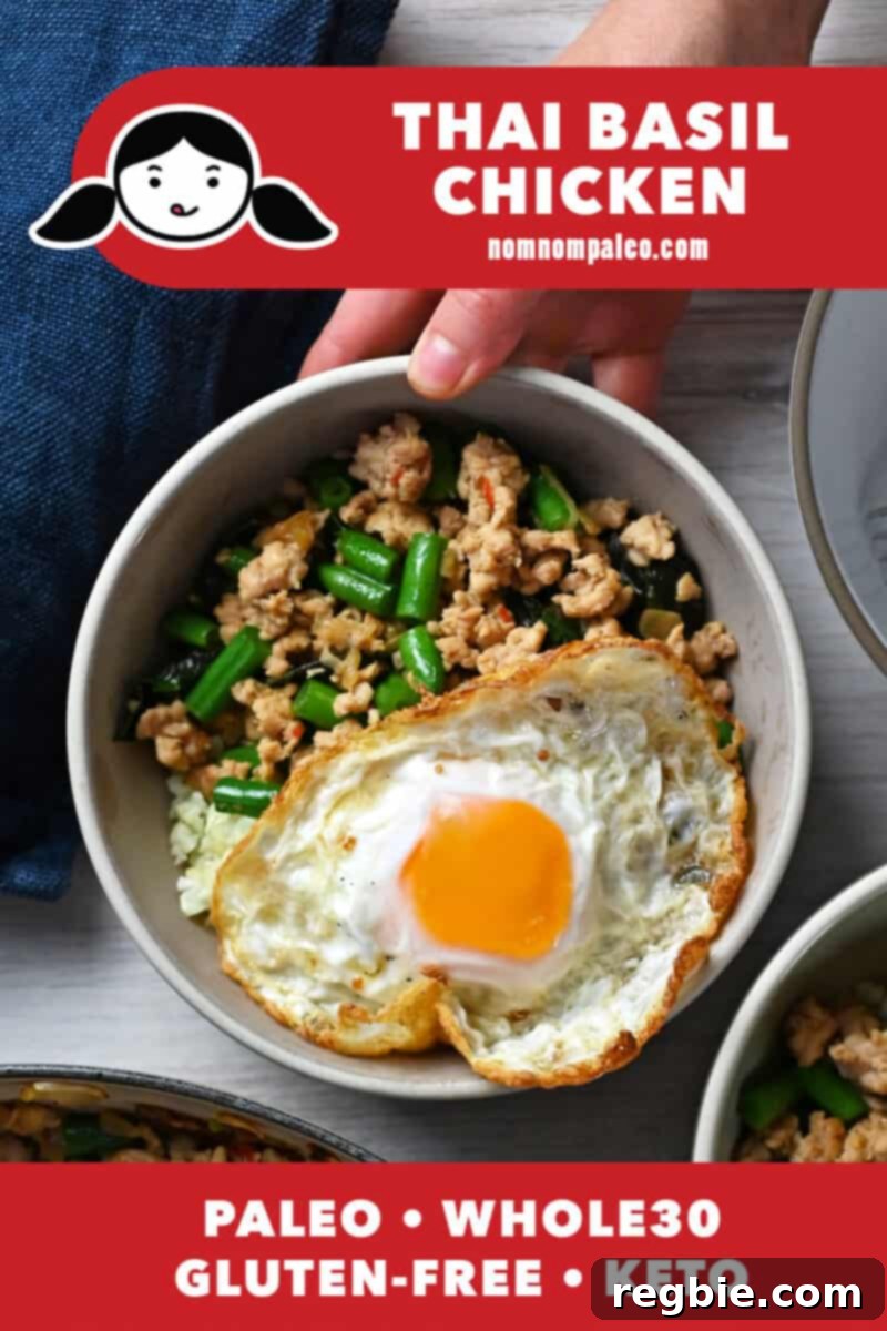 An overhead shot of Thai Basil Chicken in a bowl topped with a crispy SUNNYSIDE up egg, a paleo, Whole30, and keto meal