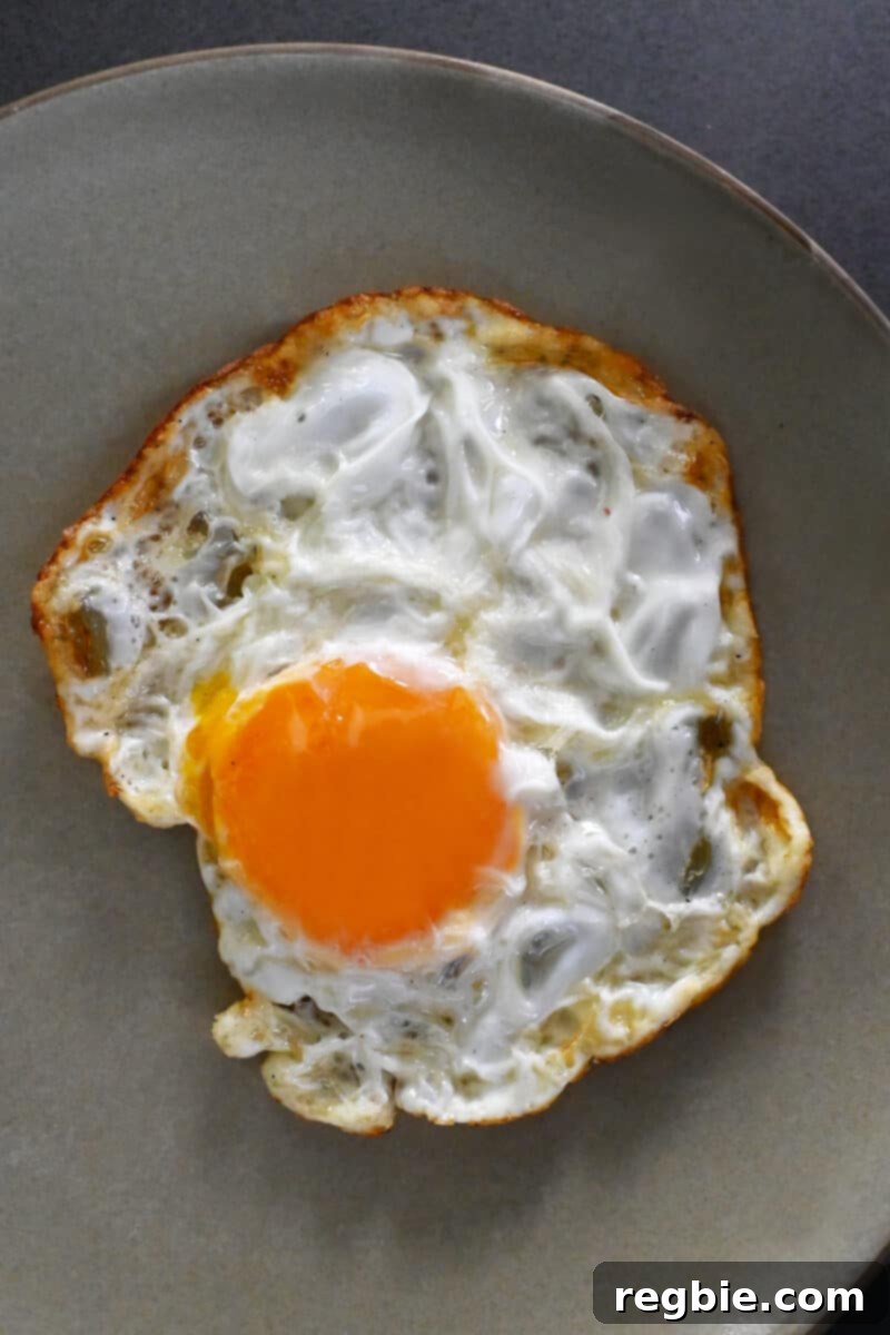 A SUNNYSIDE egg on a plate with crispy edges on the whites