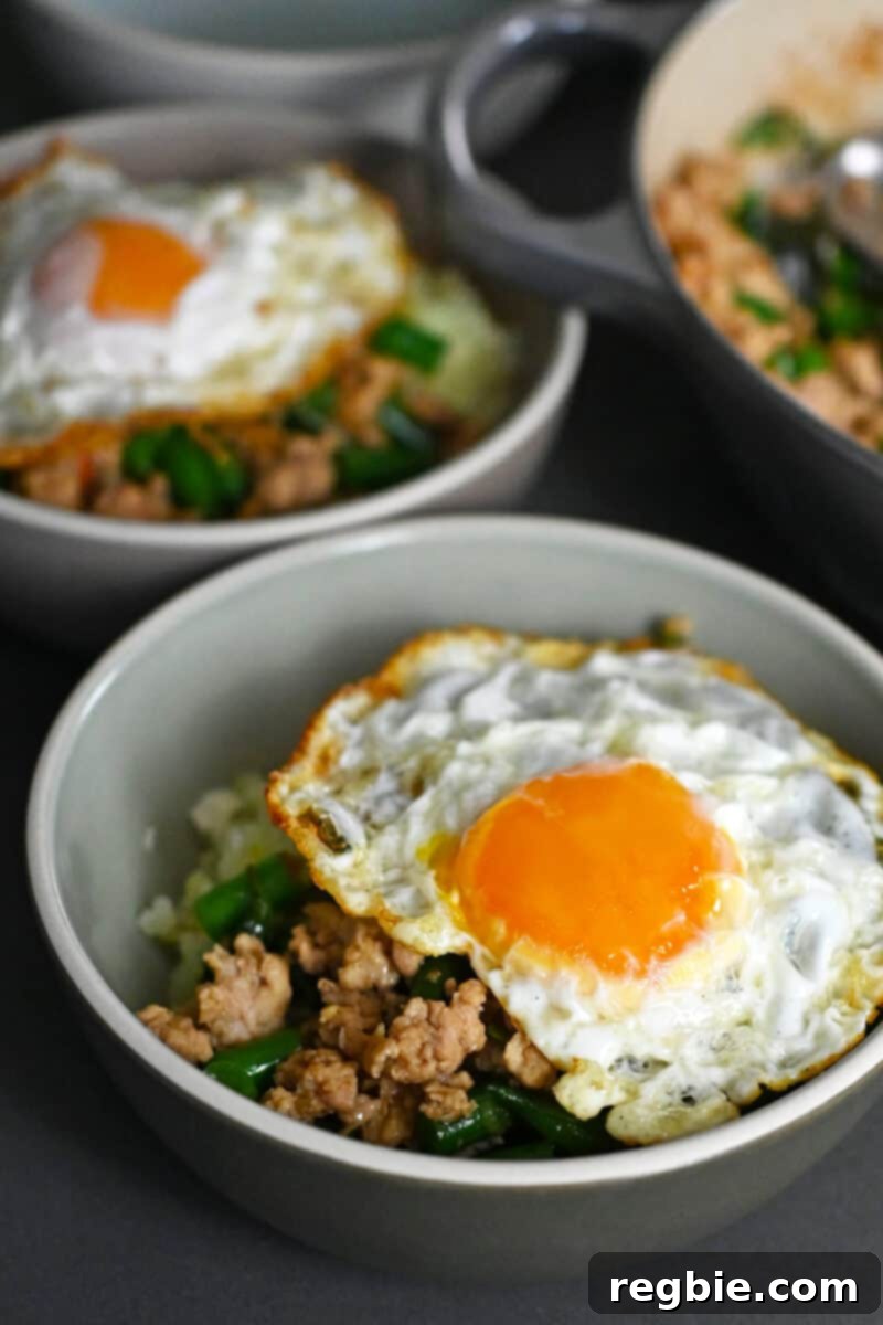 Two bowls with Thai Basil Chicken topped with crispy fried egg