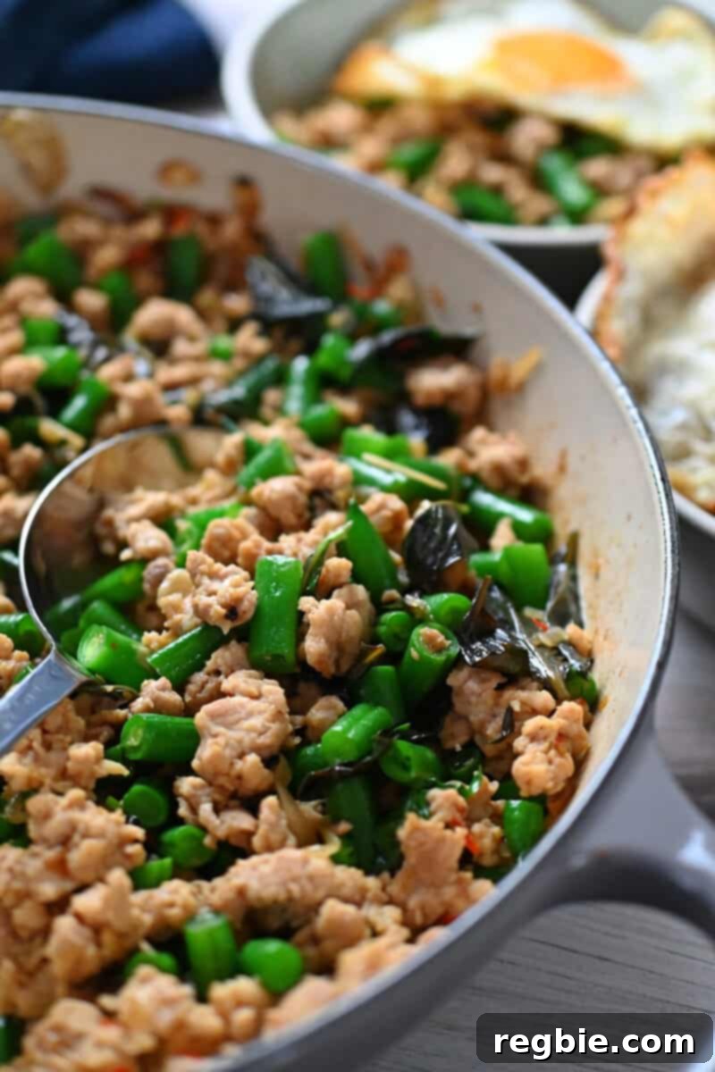 An overhead shot of a skillet filled with Thai Basil chicken