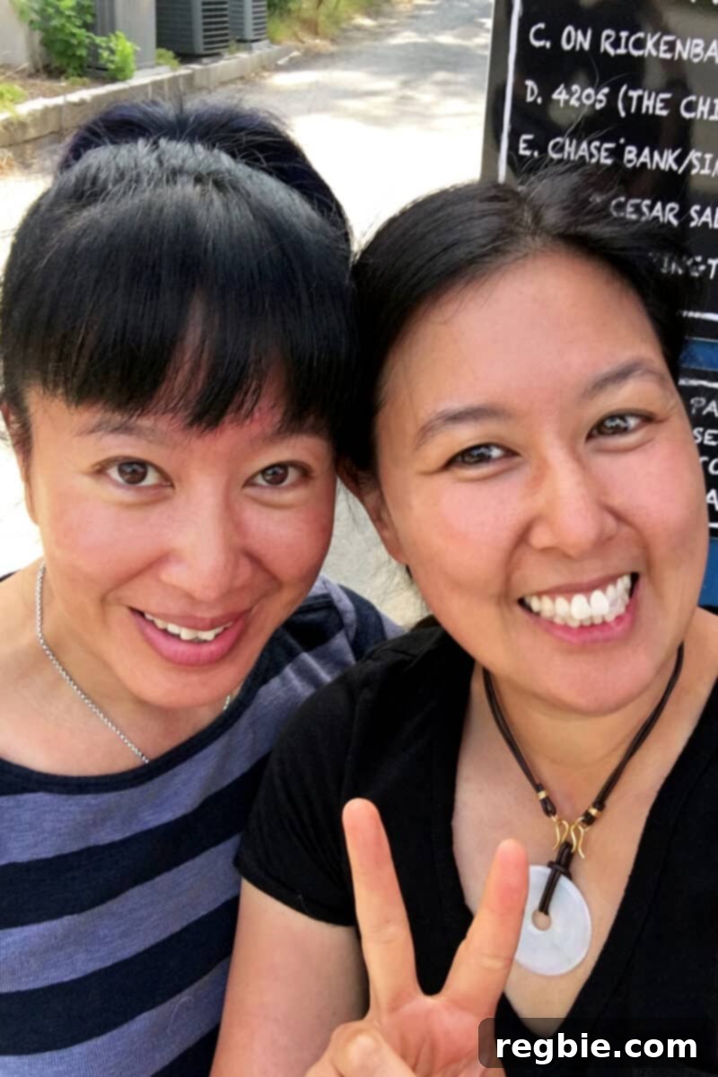 A lovely photograph featuring two smiling women, Fiona Tam Kennedy and Michelle Tam, standing together. Their joyful expressions highlight the familial bond and shared excitement behind their collaborative spice blend project.