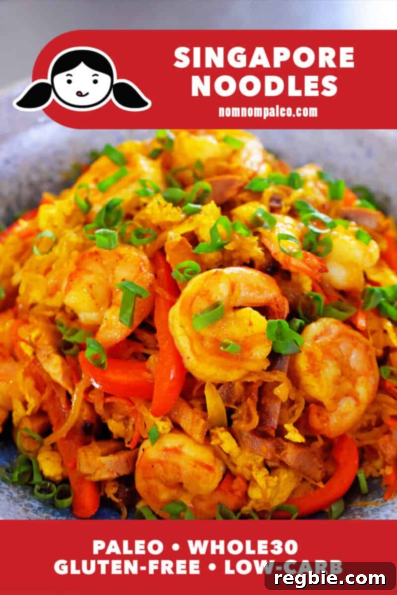 A vibrant close-up of Paleo, Whole30 Singapore Noodles, garnished with succulent shrimp and fresh scallions.