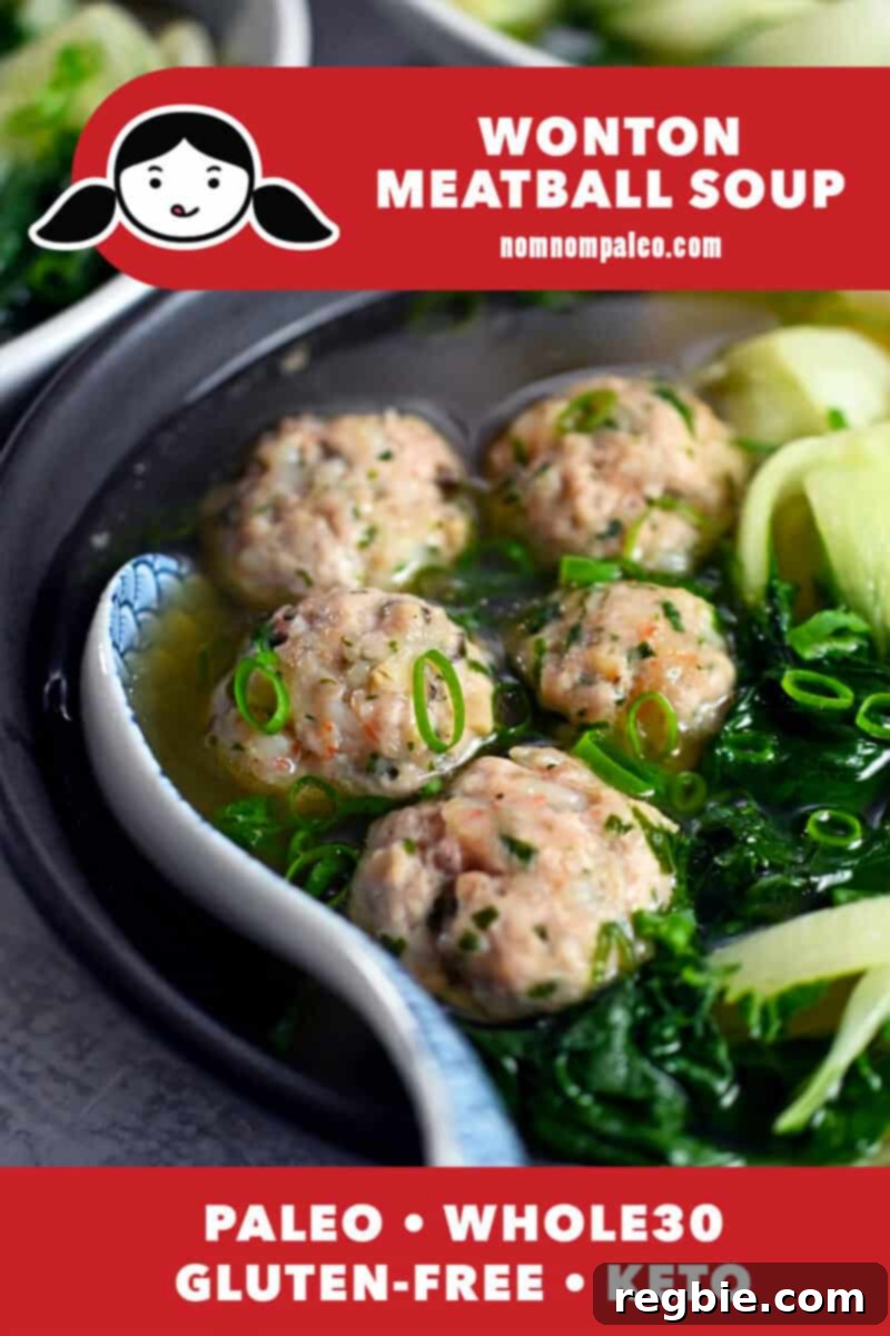 A close up of a bowl of paleo, whole30, and keto wonton soup where the bowl if filled with meatballs and baby bok choy, garnished with fresh green onions.