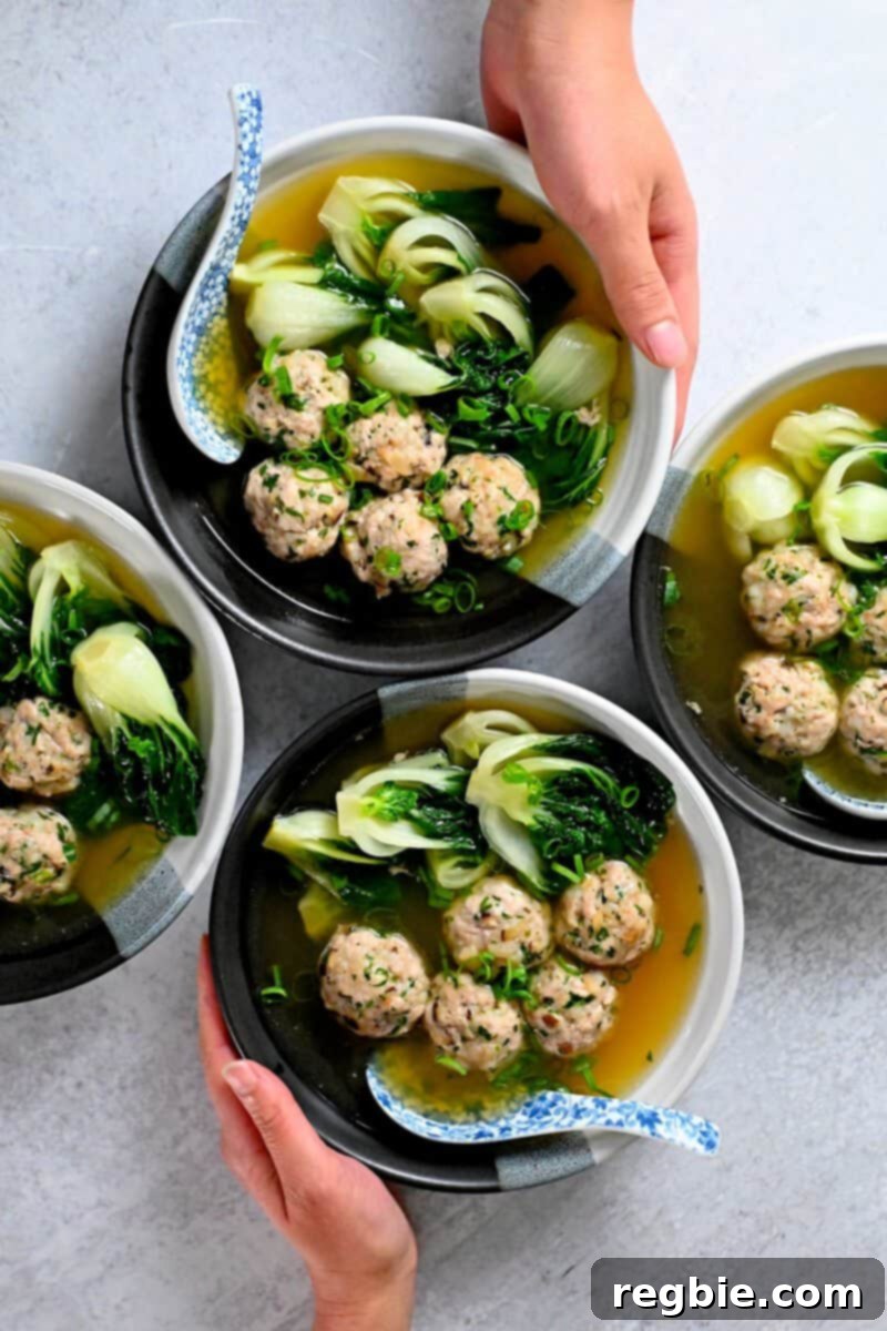 An overhead shot of four bowls of paleo, Whole30, gluten-free, keto, and low carb wonton soup, ready to be served.