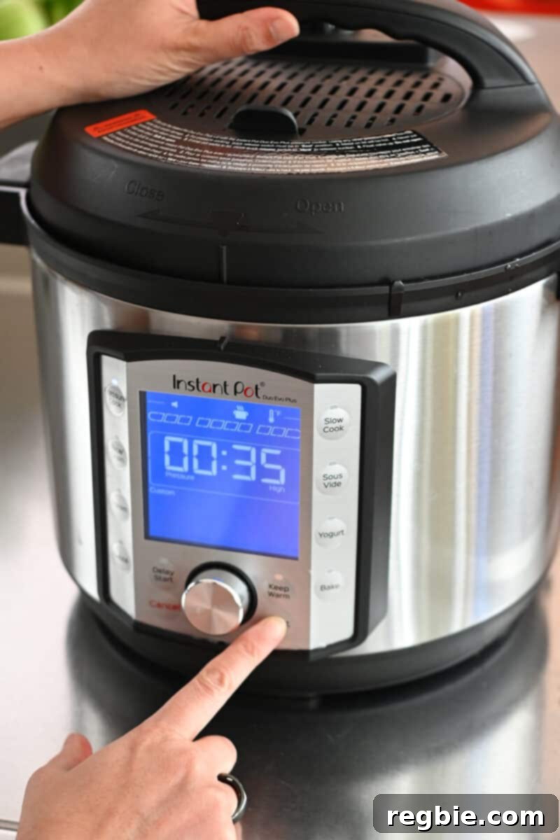 A finger is pressing a button on an Instant Pot, setting the timer for 35 minutes under high pressure.