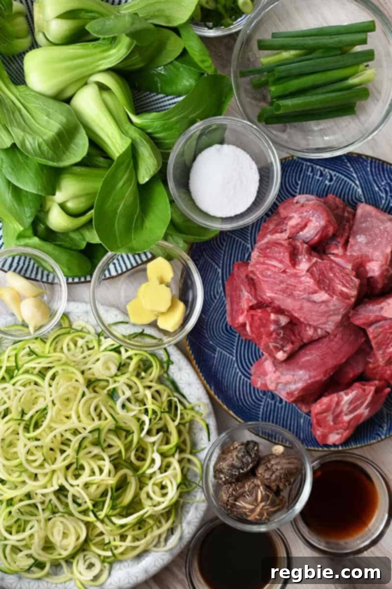 An overhead shot of all the raw ingredients for Nom Nom Paleo's Chinese Beef Noodle Soup, neatly arranged.