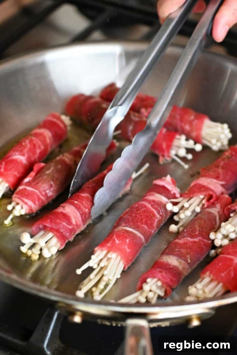 Wholesome Enoki Beef Wraps 12 Frying beef and enoki mushroom rolls in a frying pan, seam-side down.