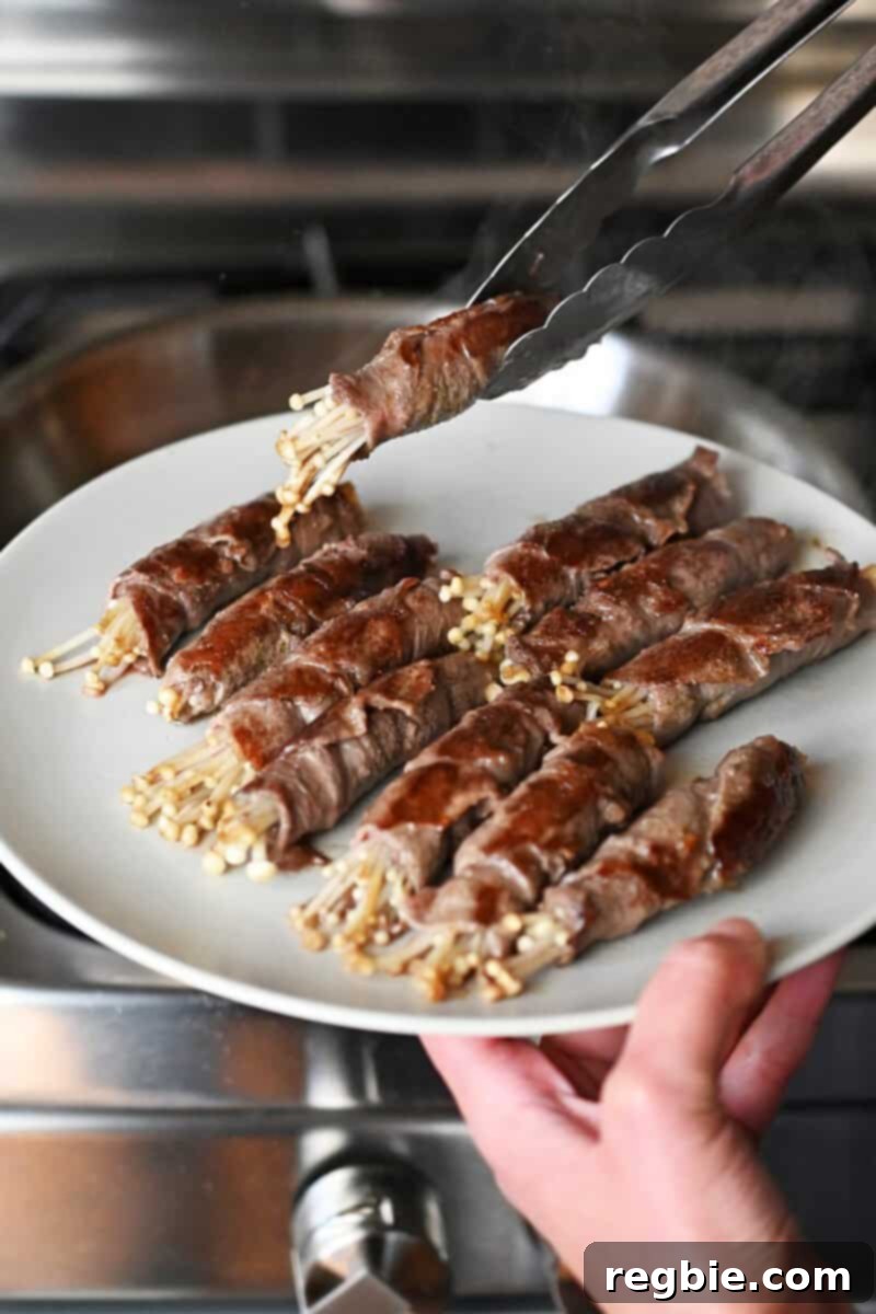 Wholesome Enoki Beef Wraps 14 Placing cooked beef and enoki mushrooms on a white plate, ready to be sauced.